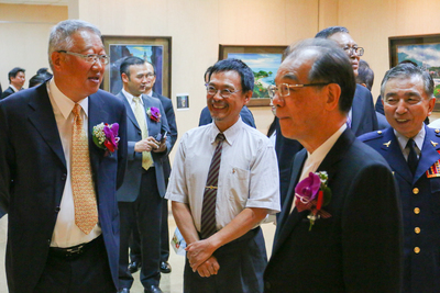 參展藝術家劉仁裕老師(中)向郭理事長台強(左一)、葉會長國一(右一)、