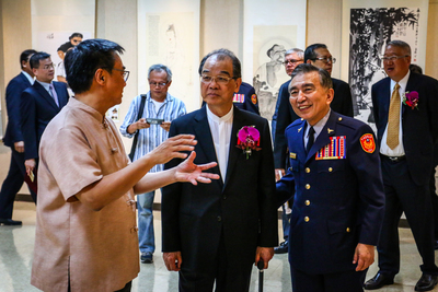 參展藝術家蕭世瓊老師(左一)向葉會長國一(中)介紹及校長畫作