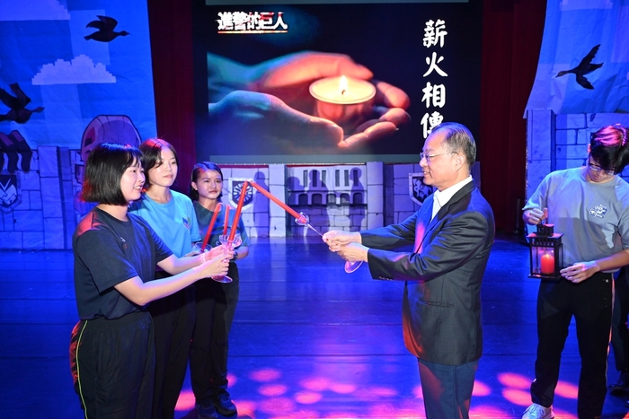 校長向3名114年新生代表傳遞薪傳之火，象徵警大精神綿延不盡。